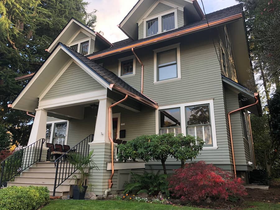 Copper K-style gutter with round downspouts and cleanout access