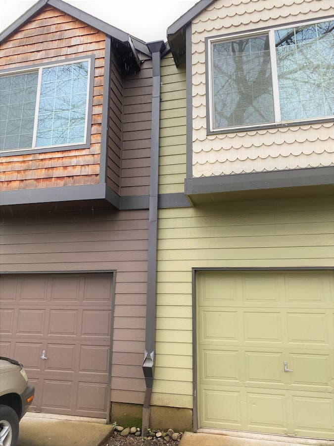 Square downspout with an accessible cleanout fitted against siding